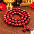 Red Sandalwood Jaap Mala – Red Wooden Mala Spiral on Temple Tabletop